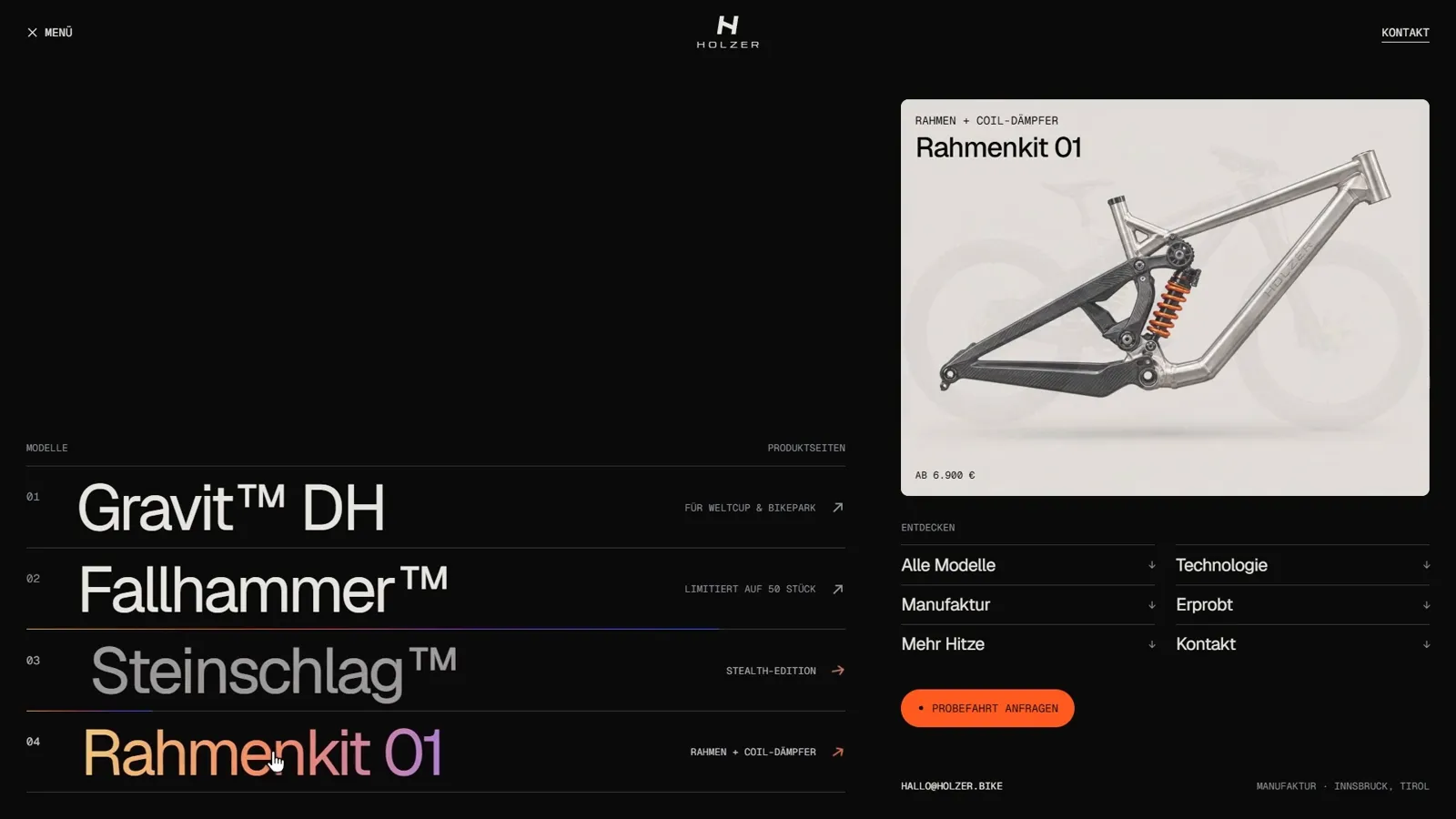 Geöffnetes Menü von holzer-bikes.com: links die Modellnamen Gravit™ DH, Fallhammer™, Steinschlag™ und Rahmenkit 01, rechts eine Vorschaukarte des Rahmenkits