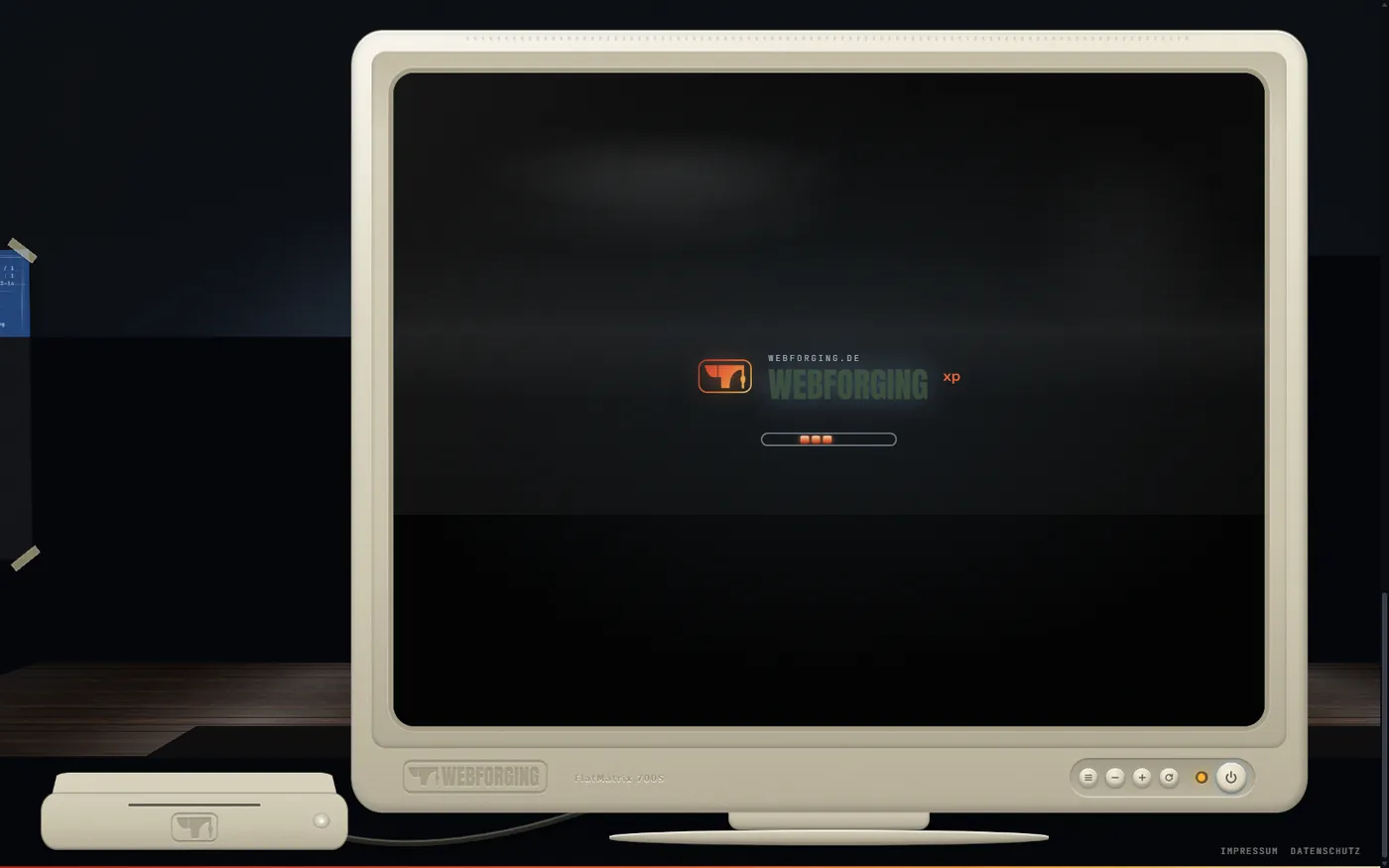 Startbild von Webforging XP auf dem Röhrenmonitor: Logo und Fortschrittsbalken auf dunklem Grund, links daneben der eingeschaltete Rechner